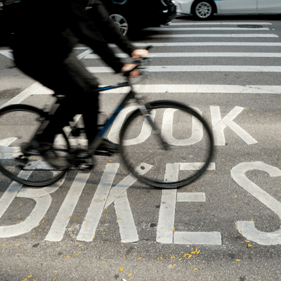 A cyclist riding on a road with bicycle pavement markings